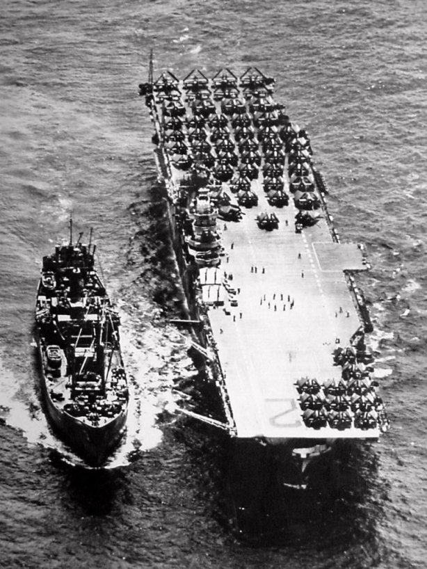 Overhead view of an ammo ship replenishing USS Hornet (CV-12), October 1944. Note the forward antenna masts half way up.