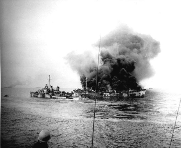 LST-738 burning after she was hit by a kamikaze off the Mindoro landing beaches, 15 December 1944. USS Moale (DD-693) is nearby. Note the hole in LST-738's starboard side, just forward of the large "738" painted there. Smoke in the left distance may be from LST-472, which was also hit by the kamikaze attack.