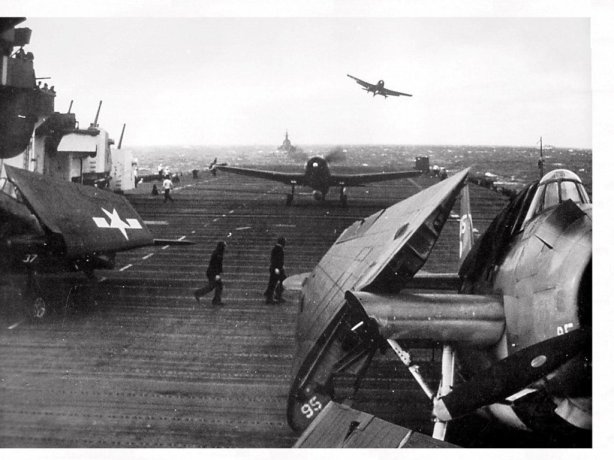 A VF-11 F6F getting a wave off while another Hellcat taxies out of the way, Dec. 1944 on USS Hornet (CV-12).